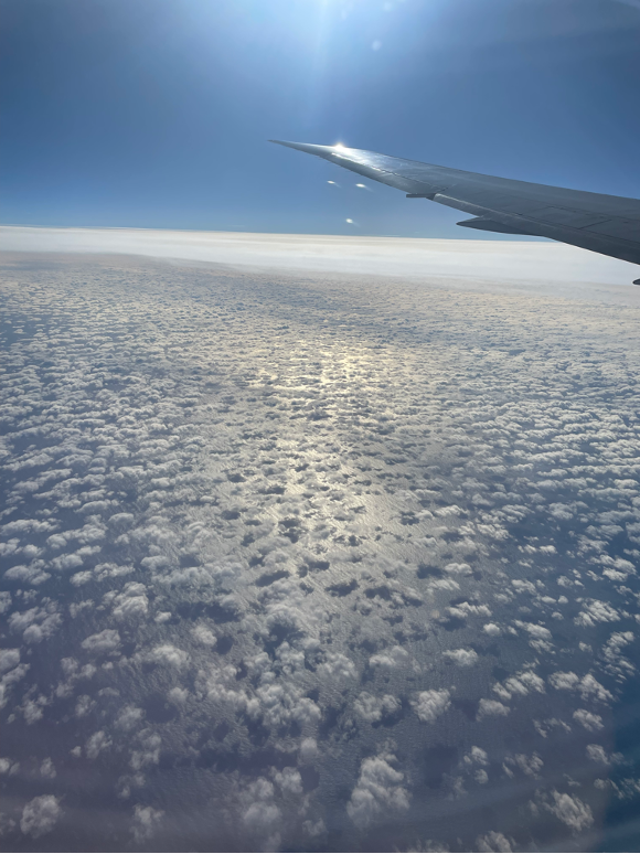 A view of clouds as seen through an airplane passenger window